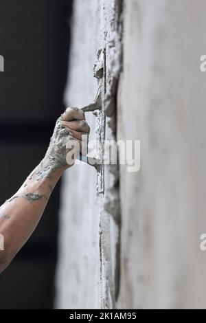 Unsafe construction of Myanmar migrant workers while plastering a wall in construction site , Thailand. Stock Photo