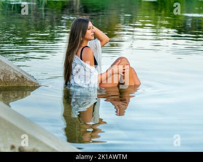 Young woman outside outdoors immersed in lake Stock Photo