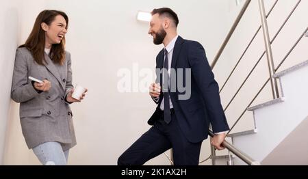office workers laughing and discussing the latest gossip during their work break Stock Photo