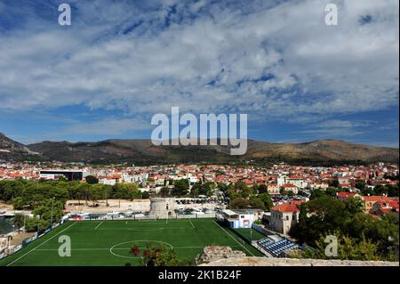 High angle view of city of Trogir, Croatia. Football field in the foreground, mountains in the back. Stock Photo