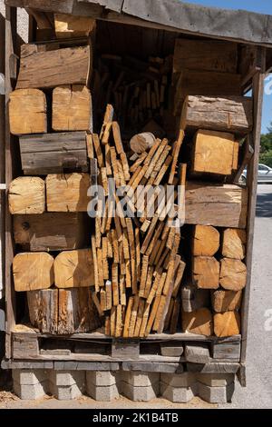 Log store with wood logs, planks and boards store, firewood supply for cold season in garden yard. Stock Photo