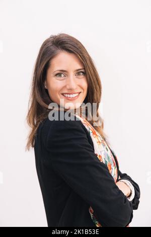 Cheerful attractive young businesswoman in formal clothes looking at camera and smiling friendly Stock Photo