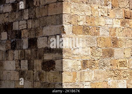 Ancient brick wall corner with a half illuminated by the sun half is in the shade Stock Photo