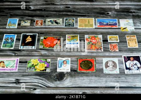 Cairo, Egypt, August 15 2022: Old used historical collection of postage stamps from different countries of the world isolated on wooden background, se Stock Photo