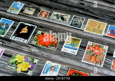 Cairo, Egypt, August 15 2022: Old used historical collection of postage stamps from different countries of the world isolated on wooden background, se Stock Photo