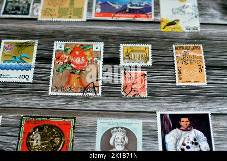 Cairo, Egypt, August 15 2022: Old used historical collection of postage stamps from different countries of the world isolated on wooden background, se Stock Photo