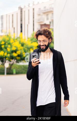 man walking happy by the city using a mobile phone Stock Photo