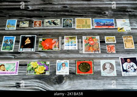 Cairo, Egypt, August 15 2022: Old used historical collection of postage stamps from different countries of the world isolated on wooden background, se Stock Photo