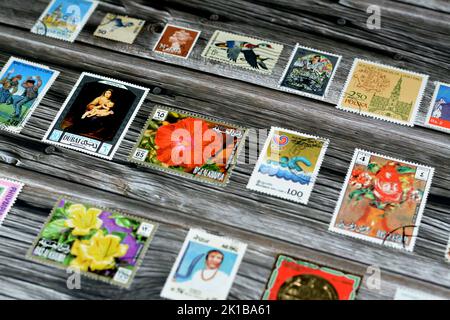 Cairo, Egypt, August 15 2022: Old used historical collection of postage stamps from different countries of the world isolated on wooden background, se Stock Photo