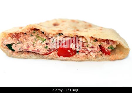 Traditional Egyptian Quraish cottage creamy cheese sandwich mixed with slices of tomatoes, olive oil and green arugula, selective focus of flat bread Stock Photo
