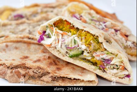 Traditional Egyptian popular breakfast street sandwiches of mashed fava beans, fried crispy falafel balls and baba ghanoush aubergine roast in flat br Stock Photo