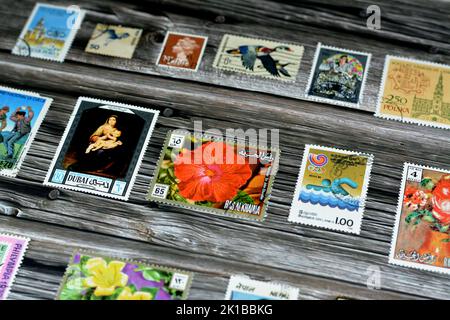 Cairo, Egypt, August 15 2022: Old used historical collection of postage stamps from different countries of the world isolated on wooden background, se Stock Photo