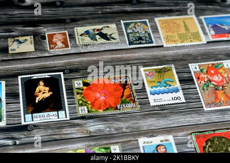 Cairo, Egypt, August 15 2022: Old used historical collection of postage stamps from different countries of the world isolated on wooden background, se Stock Photo