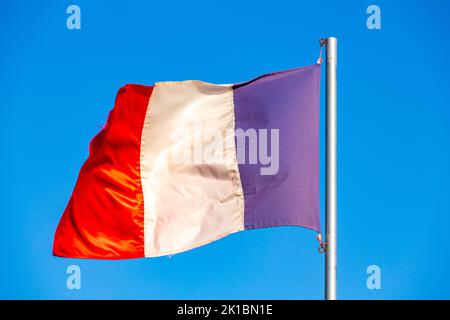 The national flag of France waving in a blue sky Stock Photo