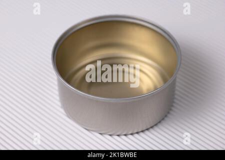 Open metal tin out over white corrugated background, close up view. Stock Photo
