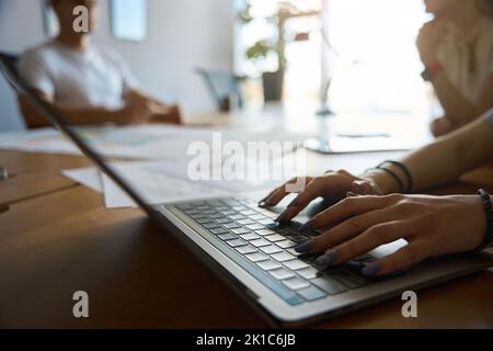 Woman hands is pressing laptop keyboard at work desk Stock Photo