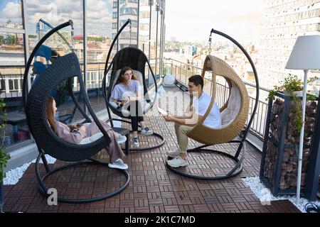 Three business colleagues are talking on terrace of business center Stock Photo