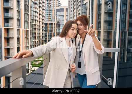 Pleased company employee pointing at something to coworker Stock Photo