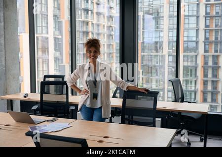Joyous stylish businesswoman posing for camera in workplace Stock Photo