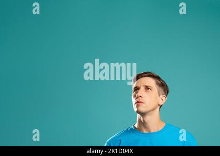 Thoughtful man. Make decision. Information banner. Actor skills. Puzzled handsome male looking up copy space isolated on blue. Advertising background. Stock Photo