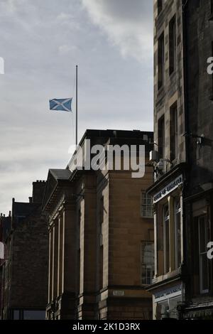 Edinburgh Scotland, UK 16 September 2022. St Andrew’s Cross flag at half mast to mark the death of Her Majesty Queen Elizabeth II over the Royal Mile. Stock Photo