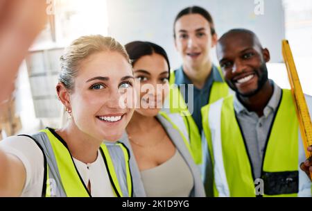 Group of industrial staff taking a selfie on a phone while working in a warehouse factory. Portrait of industry engineers taking picture in office Stock Photo