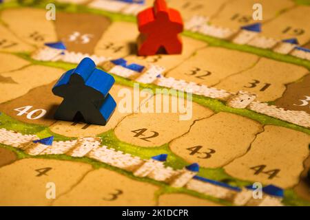 Board games meeples standing on score track close-up Stock Photo