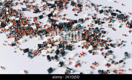 Colorful scattered tiny cylindrical electronic parts with orange and blue elements on white surface. Precision technology. Circuit board components. Horizontal shot. High quality photo Stock Photo