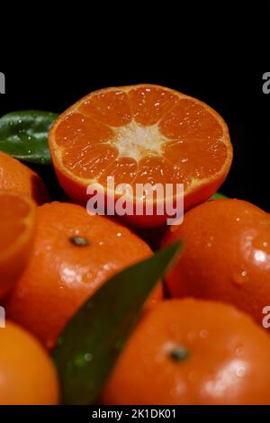 close up of mandarins with leafs, dark background Stock Photo