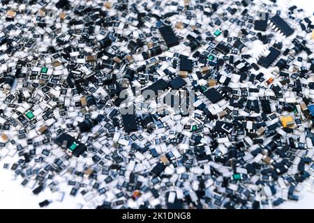 Close-up shot of scattered electrical components of circuit board in various shapes and colors on white surface. Modern technology. Horizontal. High quality photo Stock Photo