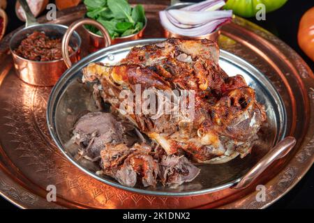 Roasting head of a lamb. Traditional Turkish Offal Food Kelle Sogus, Lamb Head Meat with Brain Served Portion served on a copper plate. Stock Photo