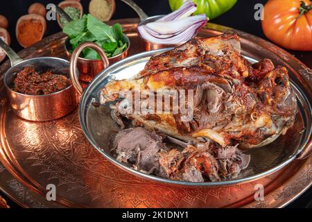 Roasting head of a lamb. Traditional Turkish Offal Food Kelle Sogus, Lamb Head Meat with Brain Served Portion served on a copper plate. Stock Photo