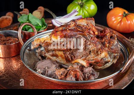 Roasting head of a lamb. Traditional Turkish Offal Food Kelle Sogus, Lamb Head Meat with Brain Served Portion served on a copper plate. Stock Photo