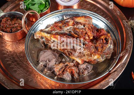 Roasting head of a lamb. Traditional Turkish Offal Food Kelle Sogus, Lamb Head Meat with Brain Served Portion served on a copper plate. Stock Photo