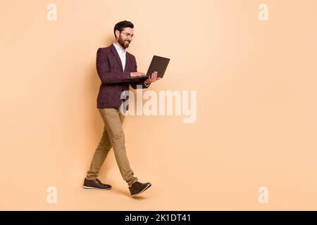 Full body profile side photo of intelligent businessman can't stop working isolated on beige color background Stock Photo