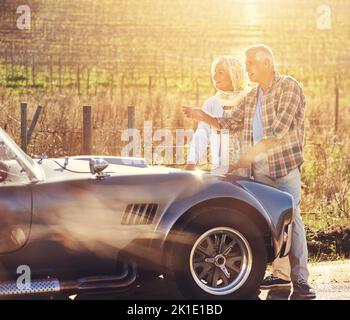 I think we were supposed to take a left back there...a senior couple looking at a map while on a roadtrip. Stock Photo