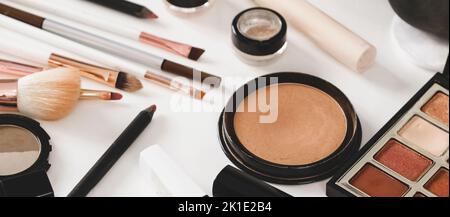 make-up tools and cosmetics on white table. Decorative cosmetics, brushes, eyes shadow, pencils with foundation on dressing table or beauty salon Stock Photo