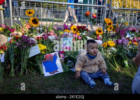Windsor, UK. 17th Sep, 2022. A toddler seen sitting next to the floral tributes outside Windsor Castle. Crowds of mourners and well wishers from all over the world continue to come to Windsor Castle to pay tribute to Queen Elizabeth II, who died on 8th September 2022. (Photo by Hesther Ng/SOPA Images/Sipa USA) Credit: Sipa USA/Alamy Live News Stock Photo