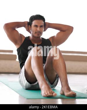 Sit up and stay focused on fitness. Full length shot of a handsome man doing situps. Stock Photo