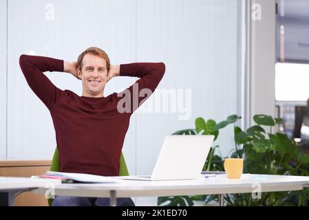 Feeling relaxed about work. A handsome businessman working at his desk. Stock Photo