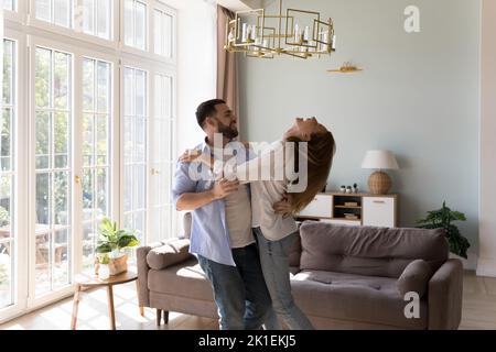 Happy handsome man teaching social dance, training excited girlfriend Stock Photo