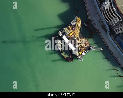 Floating crane dredging barges working on the construction of a marina. Aerial top view Stock Photo