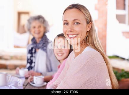 These girls love their tea. three generations of the woman of the women of a family having tea outside. Stock Photo