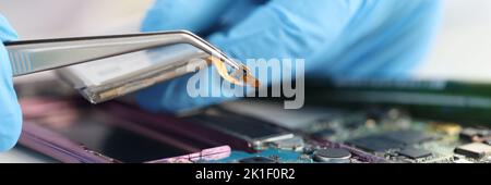 Master repairman inserting microchip into mobile phones closeup Stock Photo