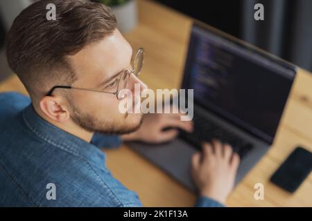 Man writing code on laptop Stock Photo