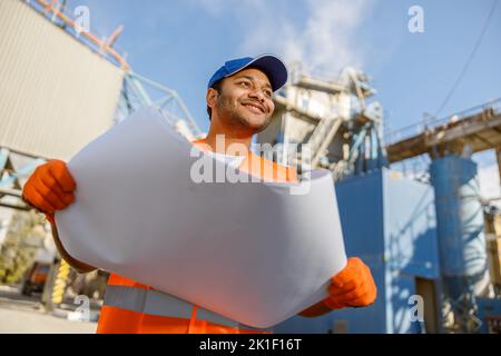 Smiling African engineer standing at industrial site Stock Photo