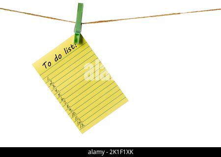 New Year New Goals. Yellow Sticky Note Paper on a clothesline isolated on white. To do list Stock Photo
