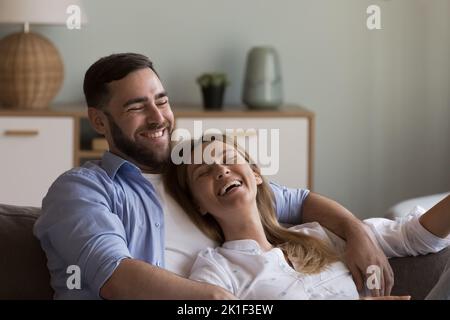 Relaxed happy dating couple in love resting on cozy couch Stock Photo