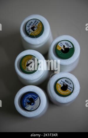 Spools of white thread on the Floor. white thread of Sewing Stock Photo