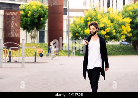 stylish young man walking using a phone at city Stock Photo